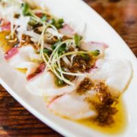 Octopus Carpaccio · Boiled octopus, sliced onions, and radish sprouts topped with a special dressing