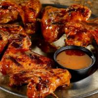 Smokin' Hot Grilled Wings · Two skewers of grilled wings with spicy chipotle sauce.