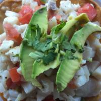 Tostada De Ceviche · Your choice of shrimp or fish, cooked in lime juice with onions, tomato, and jalapeños, topp...