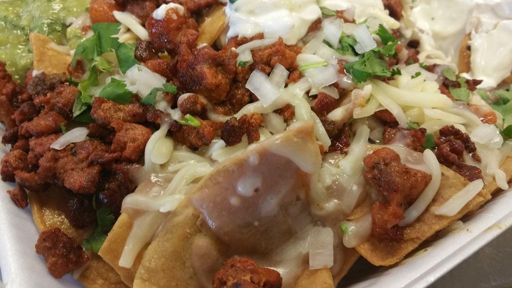 Nacho Loco · Chips, beans, cheese, meat of your choice, cilantro, onion, sour cream.