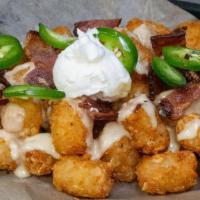 Rapture Tots · Tater Tots Topped with IPA Cheddar Sauce, Bacon, Jalapenos & Sour Cream