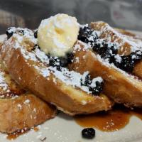 Blueberry Cakes · Blueberry cakes topped with whipped cream and blueberry syrup.