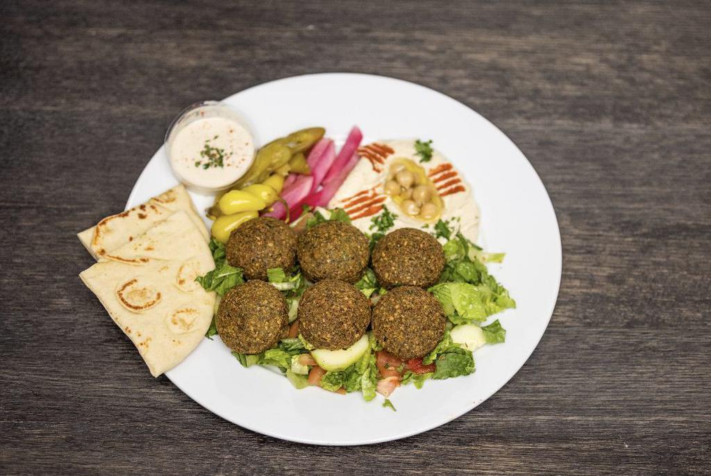 Falafel Plate · 6 pieces, served on a bed of mixed greens, pickled veggies, hummus, pita bread, and tahini sauce.