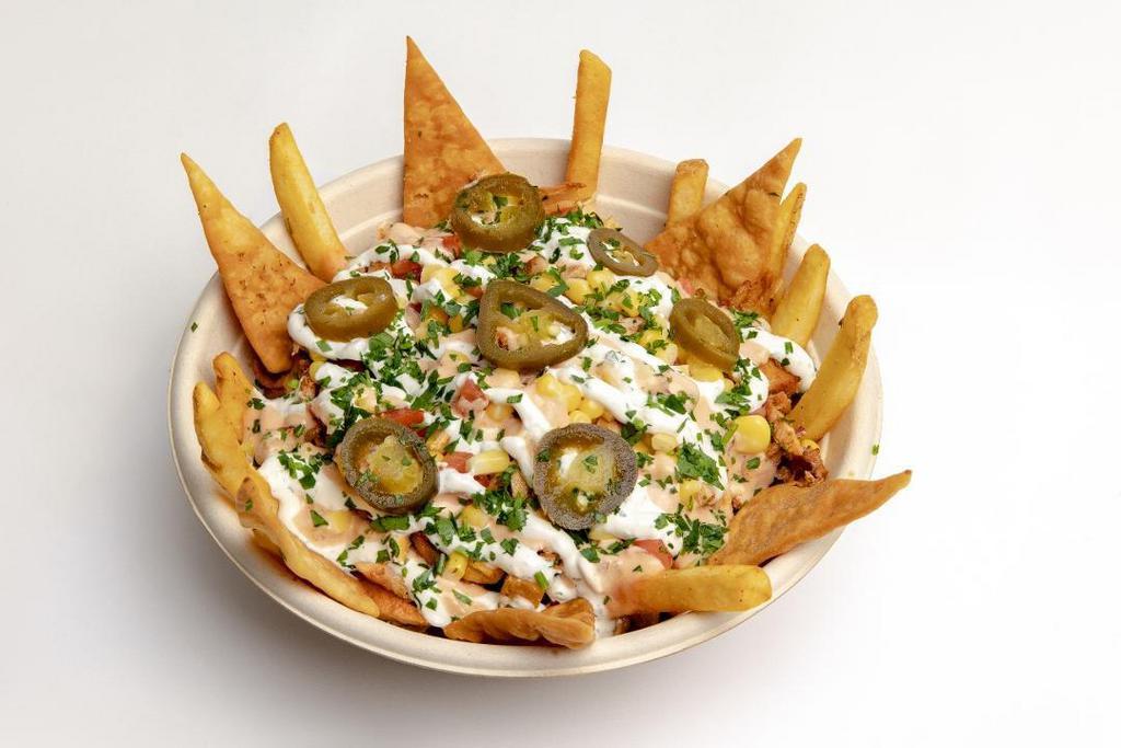 Anwar Style Chicken Shawarma · Served on a bed of seasoned fries, pita chips, thousand island, tzatziki, chopped tomatoes, corn, jalapeños, and parsley. . Includes a side of garlic and spicy sauce.