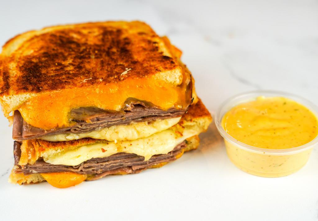 Roast Beef & Cheese Melt · Roast Beef, Cheddar, Swiss, and Parmesan cheeses melted between buttery, toasted sourdough bread. Served with a side of Spicy Honey Mustard Aioli.