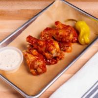 Hot Wings · Crispy fried chicken wings tossed in hot sauce and served with choice of ranch or spicy ranch.