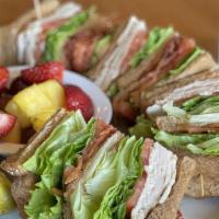 Turkey Club · Layers of lean turkey breast, bacon, lettuce, tomatoes and mayonnaise on white toast.