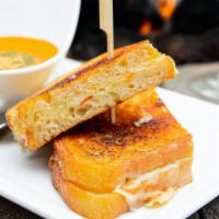 Panini Grilled Cheese · Muenster cheese, English cheddar, gruyere cheese, garlic parmesan sourdough, house- made tom...