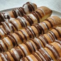 Dessert Sticks  · Nutella and Icing Drizzle on golden brown breadsticks 
Served with a side of icing