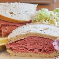 Hot Corned Beef Sandwich · Served on our Fresh Baked Rye Bread with a Pickle and choice of Cole Slaw or Potato Salad. A...