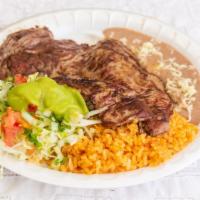 Carne Asada · Beef steak served with rice, beans, garnish salad, and tortillas.