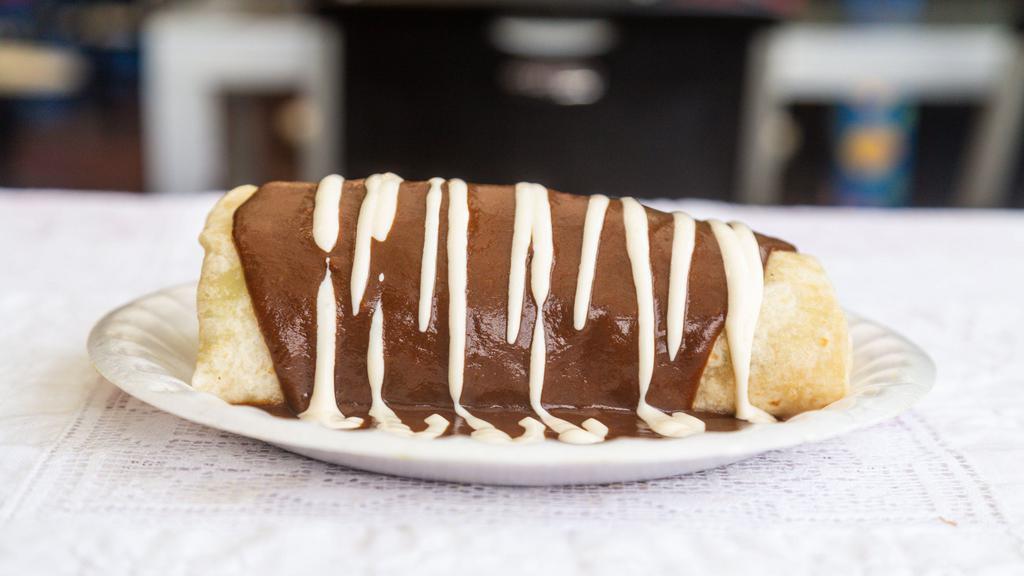 Mole Burrito · Stuffed with chicken, rice, beans, mole sauce and smothered in mole sauce with drizzled sour cream.