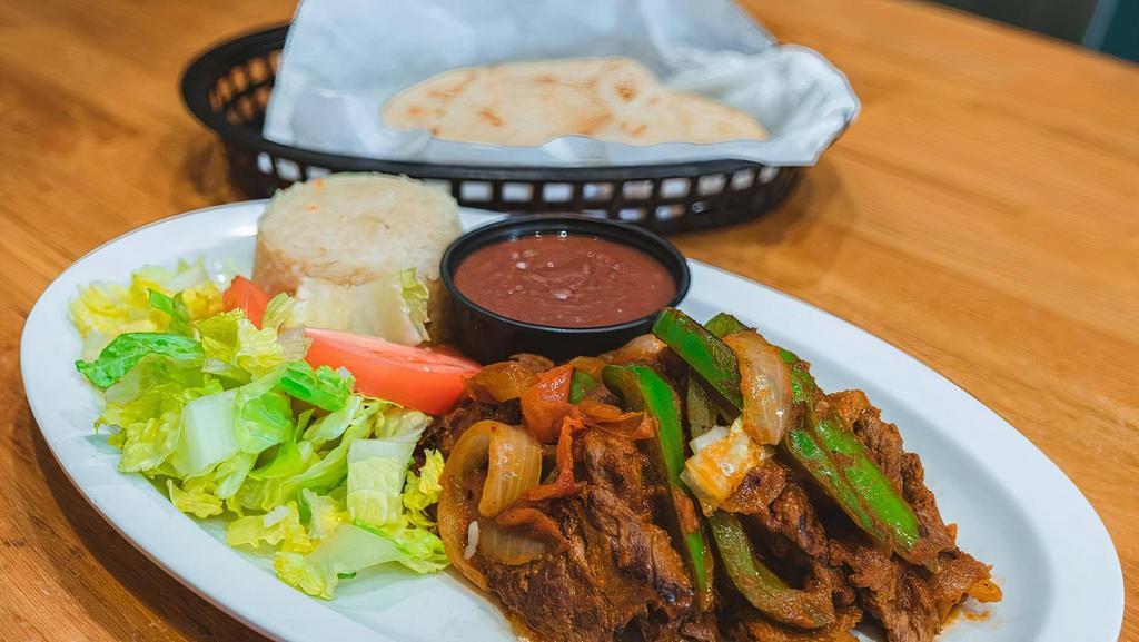 Bistec Picado · (8 ounces) Marinated flap steak tips with grilled bell pepper, tomato, and onion. Served with a choice of (3) sides, 2 handmade tortillas, and salad.