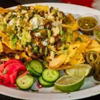 Nachos · Homemade Tortilla Chips, Nacho Cheese, Your Choice of Protein, Cilantro, Onion, Our Homemade...