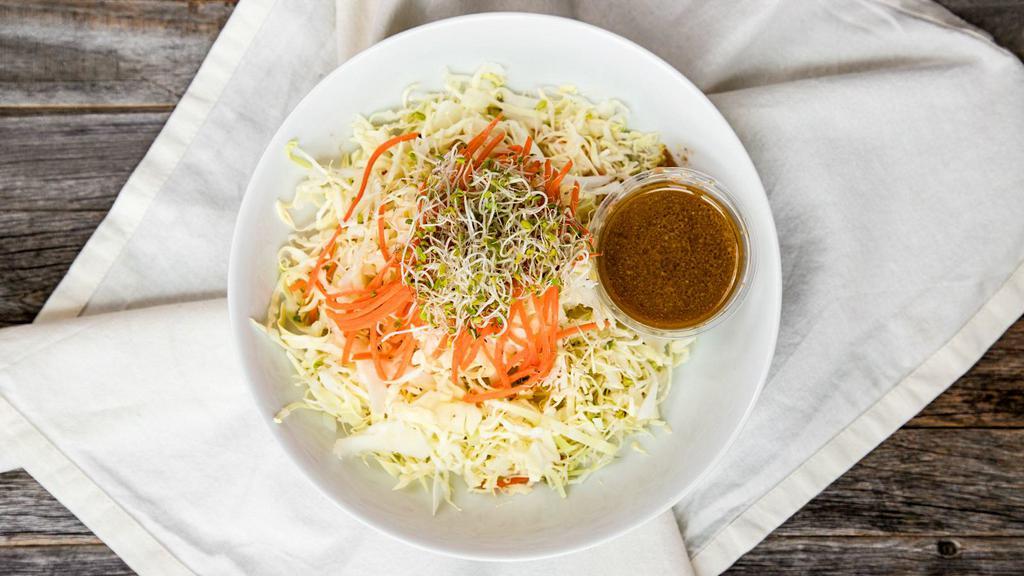 Angel Hair Salad · Gluten-free. Thinly shaved cabbage and carrots with sprouts. Served with our organic garlic-sesame dressing.