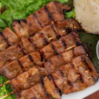 Moo Yang · Thai style pork skewers. Marinated pork skewers grilled over an open flame. Served with stic...