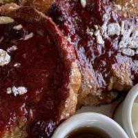 Brioche French Toast · With toasted almonds, strawberries, syrup, and bacon.