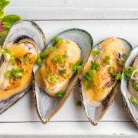 Baked Green Mussels · Dynamite baked mussels (in), green onion and wasabi mayo (top).