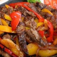 Sizzling Steak Fajitas · Grilled steak with bell peppers and onions, served with Spanish rice and beans, guacamole, s...