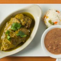 Costillas De Puerco · Pork spare ribs braised in a green tomatillo salsa. Served with rice, beans and tortillas.