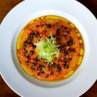 Salmon Carpaccio · with black truffles, diced tomatoes, frisee, ginger soy vinaigrette, and truffle oil