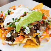 Nachos · Your choice of meat, beans, cheese, tomato, onions, cilantro, sour cream, and guacamole.