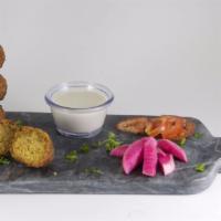 Falafel - 4 Pieces · Fried chickpea and fava bean fritters seasoned with garlic, onions and spices. - VEGAN