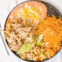 Carnitas · Tender pieces of seasoned braised pork presented on a bed of sautéed vegetables with guacamo...