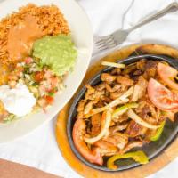 Combination Fajitas · Strips of marinated steak and chicken cooked in our Achiote glaze served on a bed of sautéed...