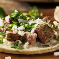 Steak Taco · Tacos served with onion, cilantro, radish, and lime, with a choice of green or red sauce.