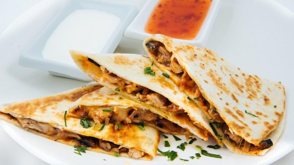 The Carnitas Quesadilla · Grilled flour tortilla filled with melted cheese, flavorful carnitas (pork) sour cream, and guacamole.