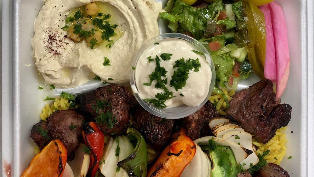 Lamb Shish Kabab · Two skewers of tenderloin sirloin lamb cubes grilled to perfection. Served with Basmati rice, hummus & salad.