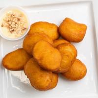 Thai Donuts · Thai donuts served hot and topped with a sweet condensed milk sauce and crushed peanuts.