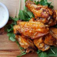 Wood-Fired Buffalo Wings · 6 spicy wings smothered in our housemade buffalo sauce. Served on a bed of arugula with a si...