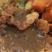 Smothered Pork Chop · 2 pork chops with rice and gravy, two sides and muffin.