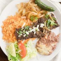 Carne Asada Plate · Grilled beef steaks served with rice, beans, and salad