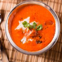 Butter Chicken · Boneless pieces of chicken cooked in rich tomato sauce, cream and butter.