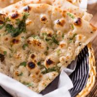 Garlic Naan · White flour dough with milk and butter and topped with grated garlic baked in a clay oven.