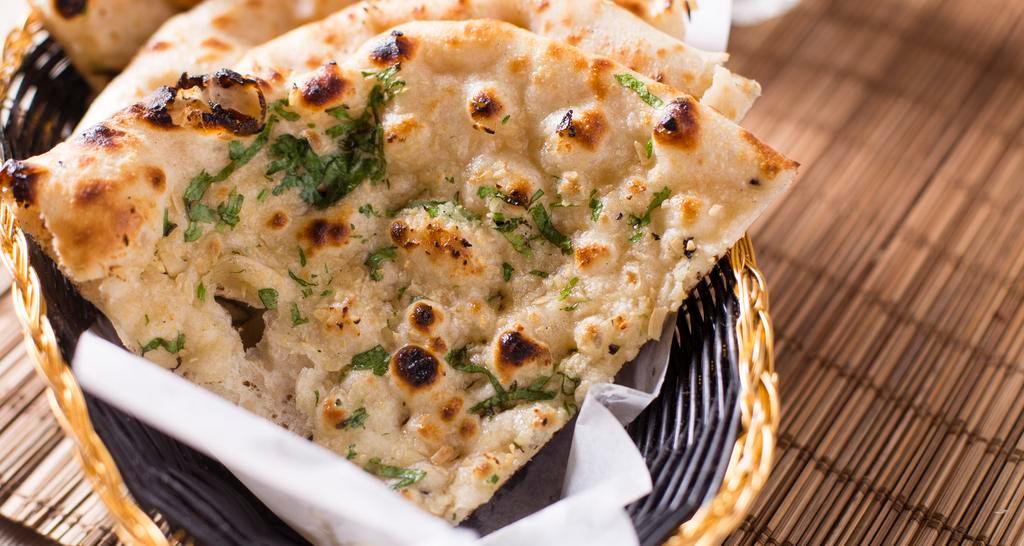 Garlic Naan · White flour dough with milk and butter. topped with grated garlic baked in clay oven.