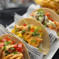 Fish Tacos · (choice of 3). Served on a blended corn & flour tortilla with cabbage & shredded cheese. Gri...