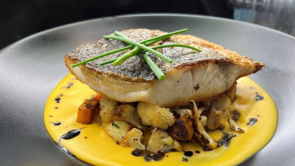 Baja Striped Bass · Pan roasted baja striped bass served over butternut squash, roasted cauliflower, and sweet potatoes. Finished with a butternut squash puree and balsamic reduction.
