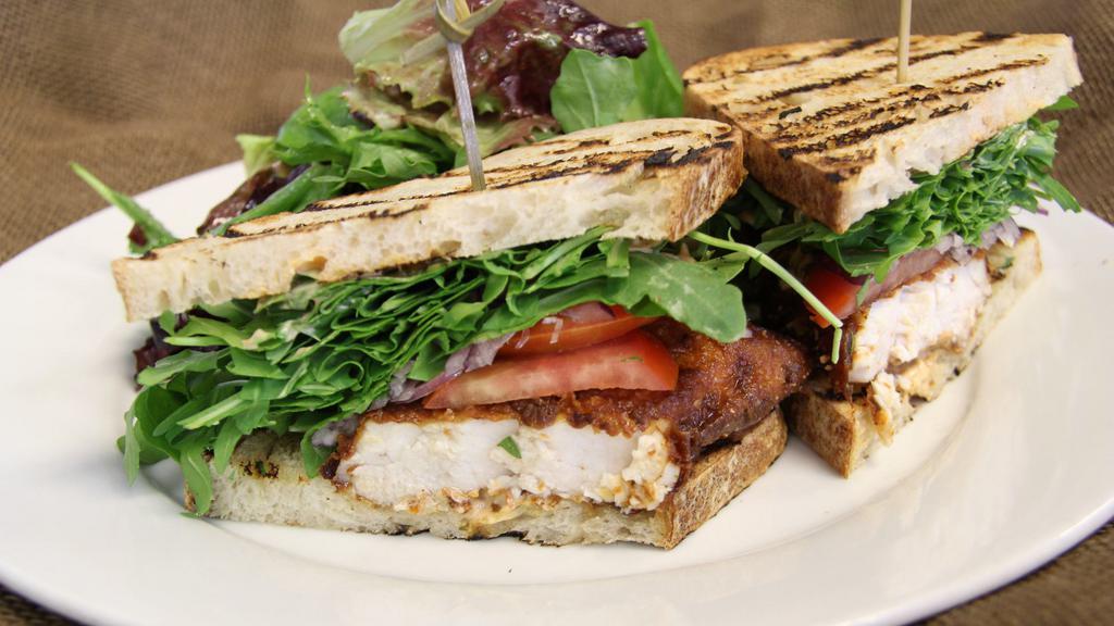 Grilled Swordfish Sandwich · Served on grilled sourdough bread with avocado, arugula, tomatoes, red onions, and pesto aioli