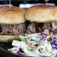 Bbq Pulled Pork Sliders · Two mini buns filled with pulled pork, BBQ sauce and coleslaw on the side.