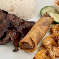 Com Thịt Bò Nướng, Tôm, Chả Gi · Grilled beef, grilled shrimp and egg rolls over steam rice.
