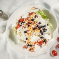 Wedge Cobb Salad · Crisp iceberg wedge topped with blue cheese crumbles, house bacon, cherry tomatoes, farm fre...