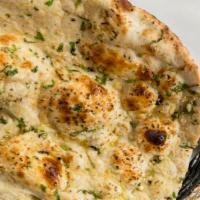 Garlic Naan · Naan garnished with freshly chopped garlic and baked in the tandoori topped with cilantro.