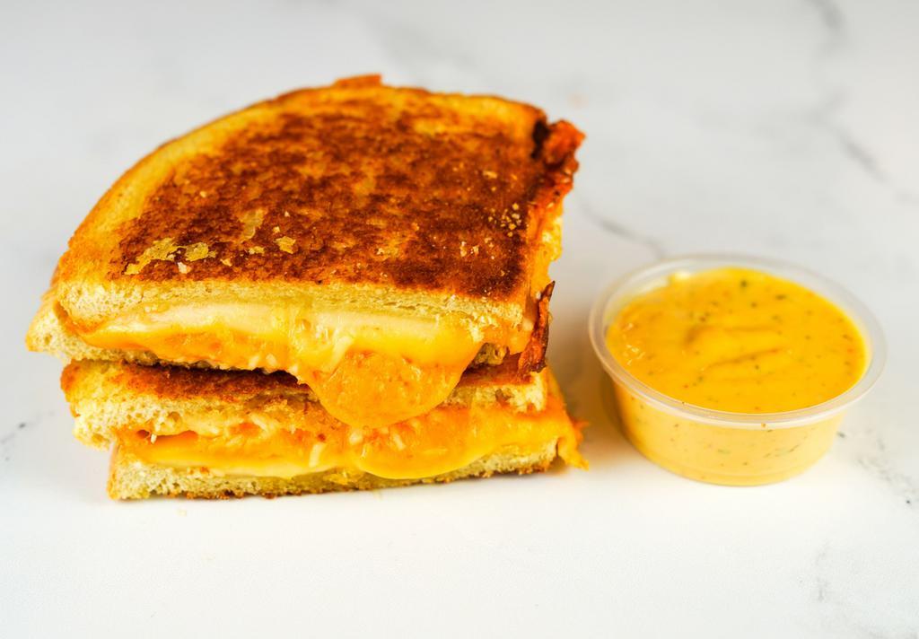 Three Cheese Grilled Cheese · Cheddar, Swiss, and Parmesan cheeses melted between buttery, toasted sourdough bread. Served with a side of Spicy Honey Mustard Aioli.