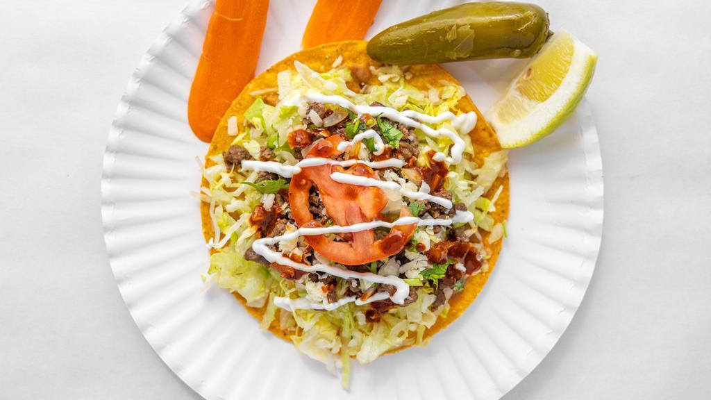 Tostada · Your choice of meat, cilantro, salsa, cheese, lettuce, tomatoes and sour cream.