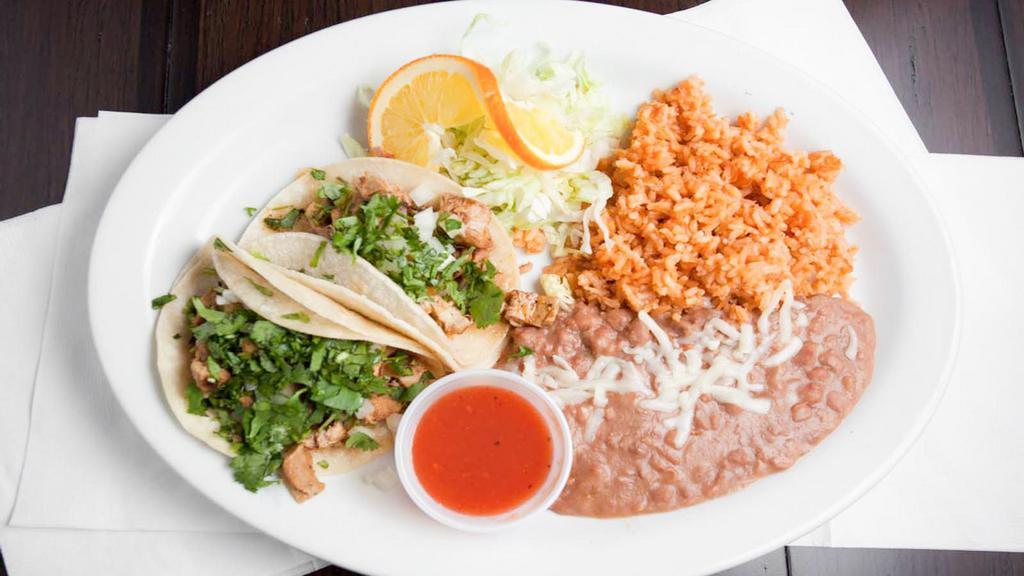 Two Tacos Plate · Two soft corn tortilla tacos topped with choice of meat, onion, cilantro, and served with rice and beans. Salsa served on the side.