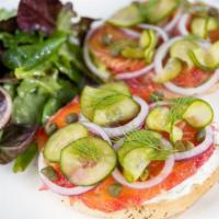 House Cured Salmon Bagel · choice of plain or everything bagel, herbed cream cheese spread on one side and smashed avoc...